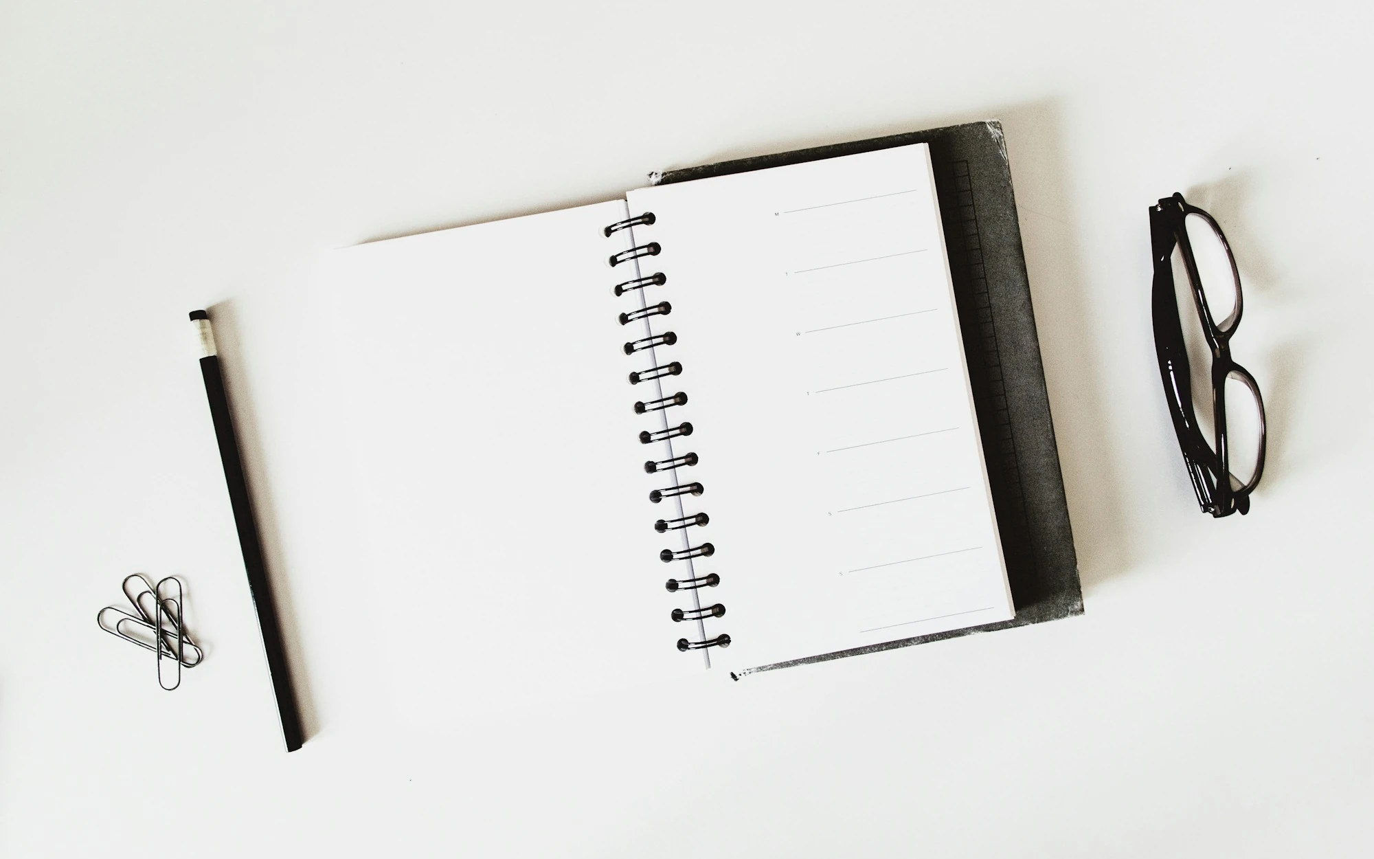 spiral notebook and black pen